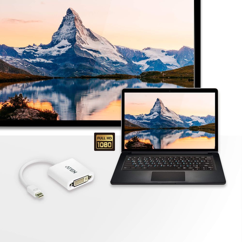 Un adaptateur Mini DisplayPort vers DVI blanc devant un ordinateur portable et un moniteur avec paysage de montagne.
