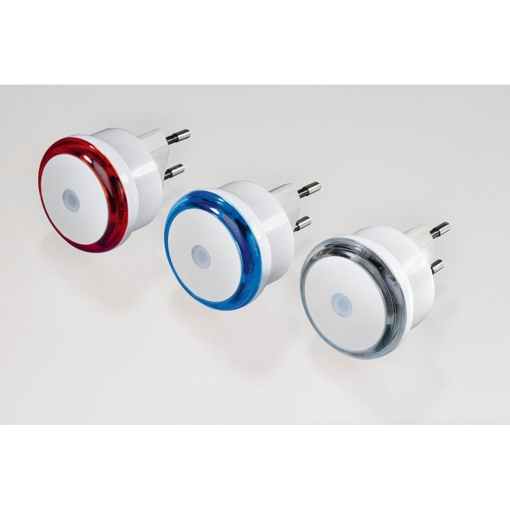 Tres luces nocturnas blancas con anillos rojos, azules y transparentes en una superficie blanca.