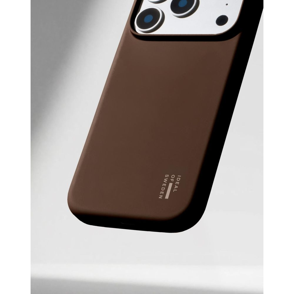 Uno smartphone in una custodia marrone con la scritta Ideal of Sweden su sfondo bianco.