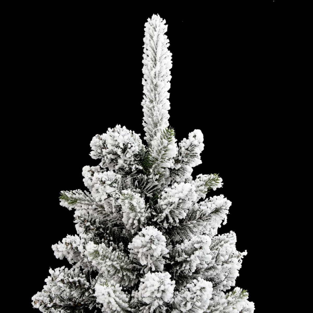 Ein künstlicher Tannenbaum mit künstlichem Schnee auf den Zweigen vor schwarzem Hintergrund.