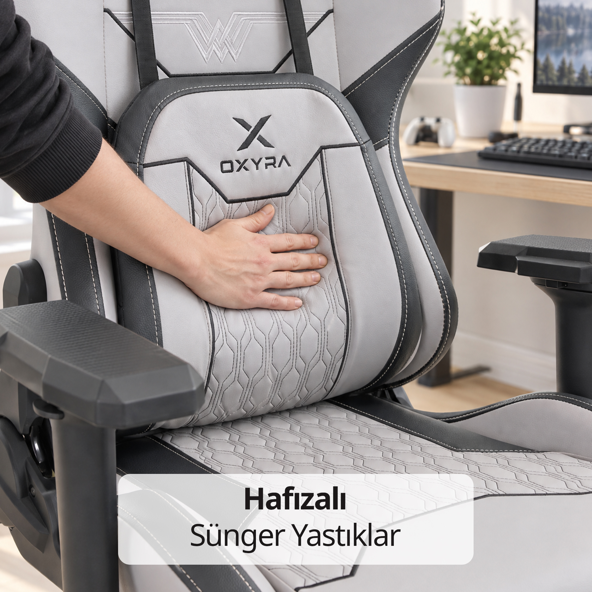 Bir Oxyra oyuncu koltuğunun gri ve siyah minderine bastıran bir el.