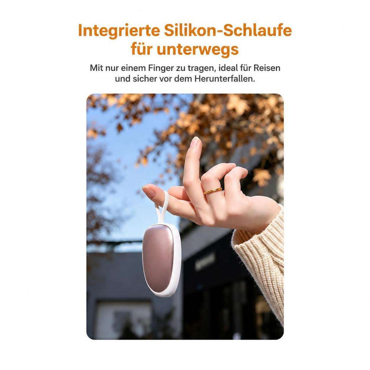 Eine Hand trägt ein kleines ovales Gerät mit Silikonschlaufe am Finger, mit Text oben.