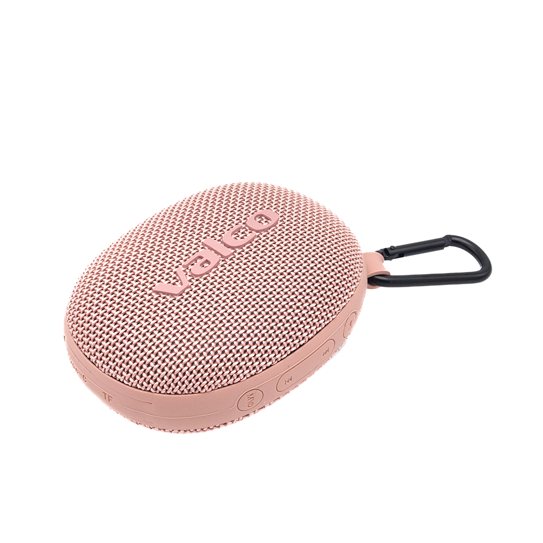 Ein ovaler, rosafarbener Valco-Bluetooth-Lautsprecher mit Stoffbezug und schwarzem Karabinerhaken auf schwarzem Grund.