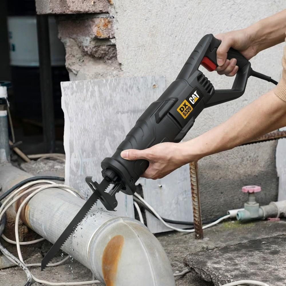 Bir kişi açık havada siyah bir CAT kılıç testere ile metal boru kesiyor.
