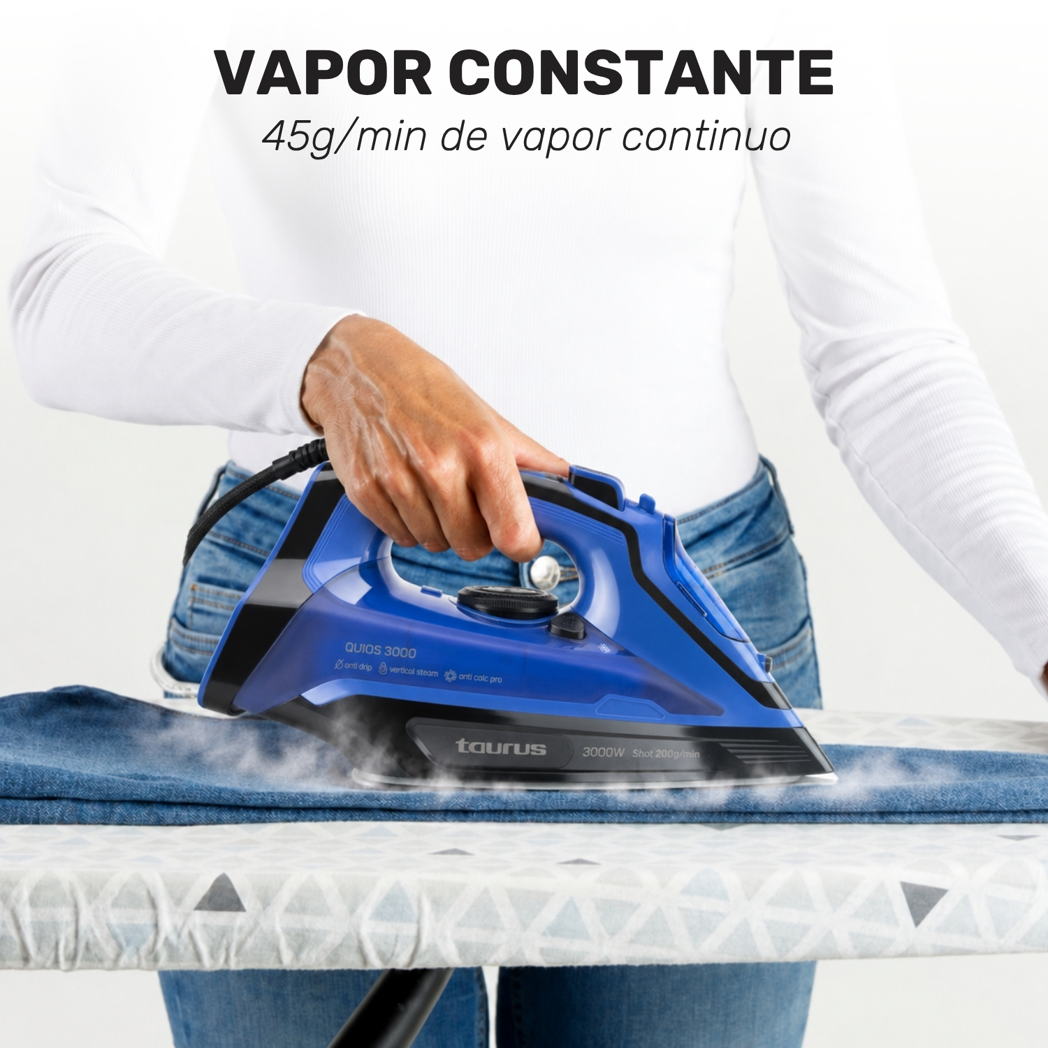 Persona planchando vaqueros con una plancha de vapor azul Taurus, emitiendo vapor.