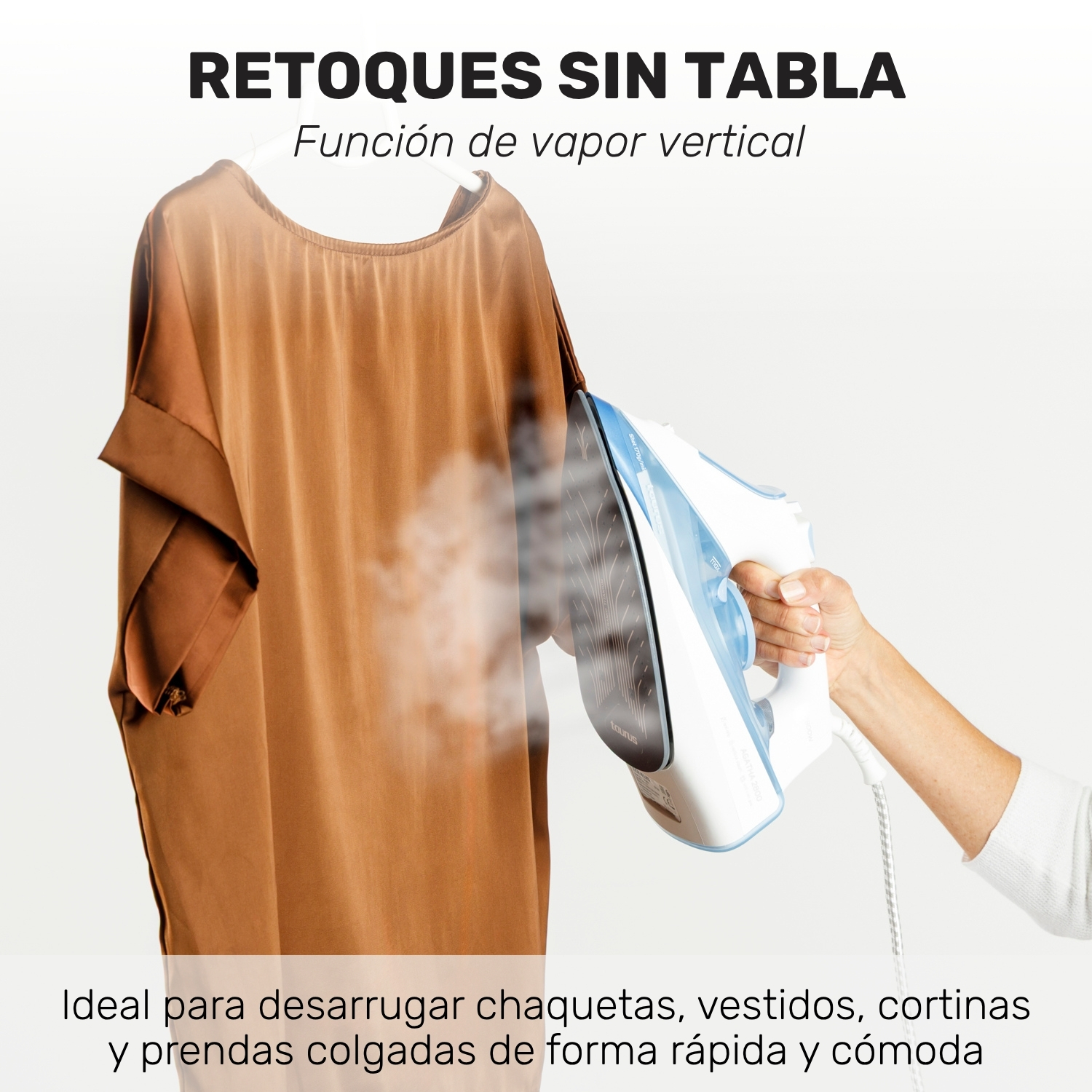 Mano sostiene una plancha de vapor para planchar un vestido marrón colgado.