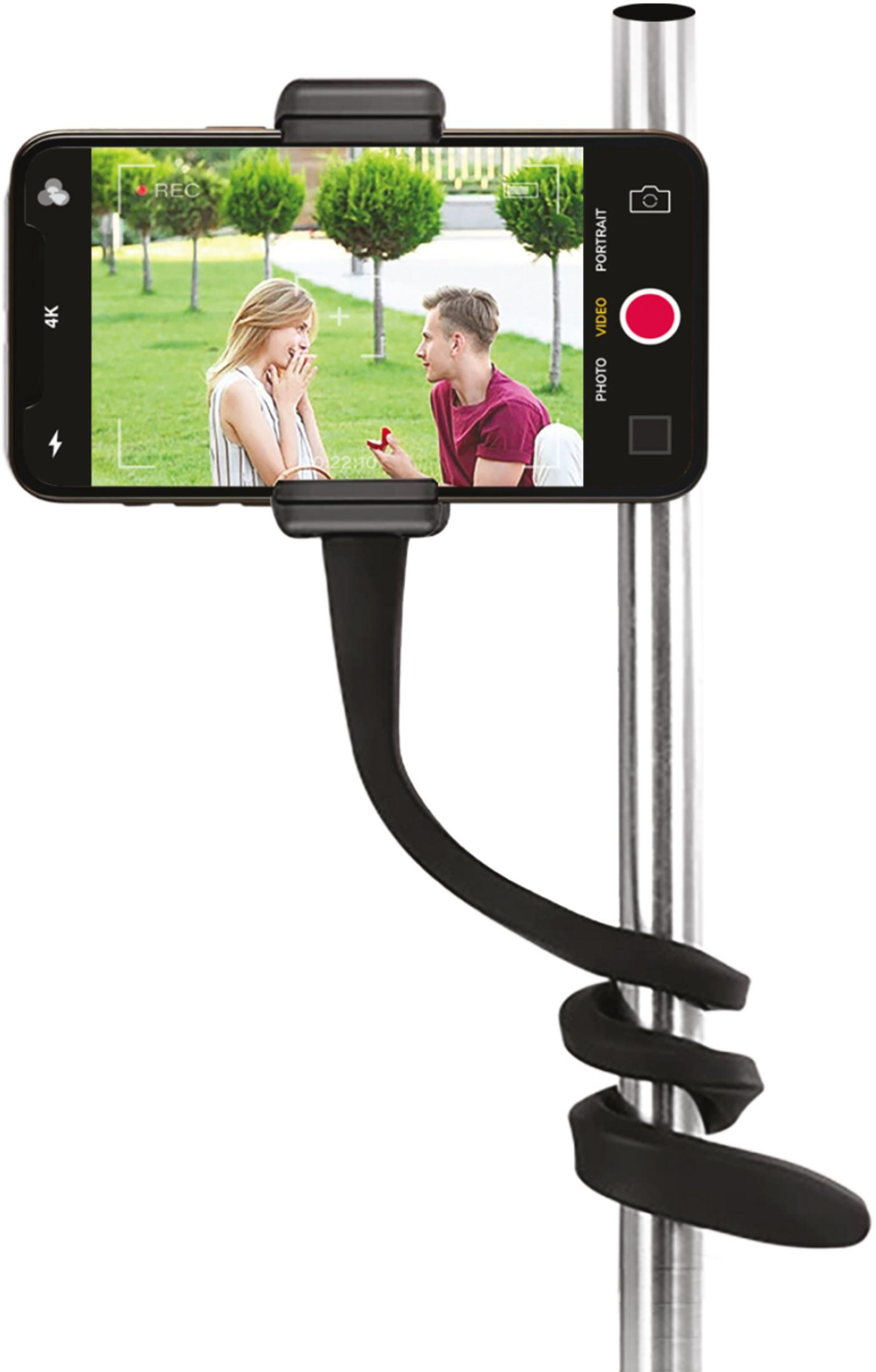 Un teléfono en un soporte flexible enrollado en un poste muestra a una pareja en un parque en su pantalla.