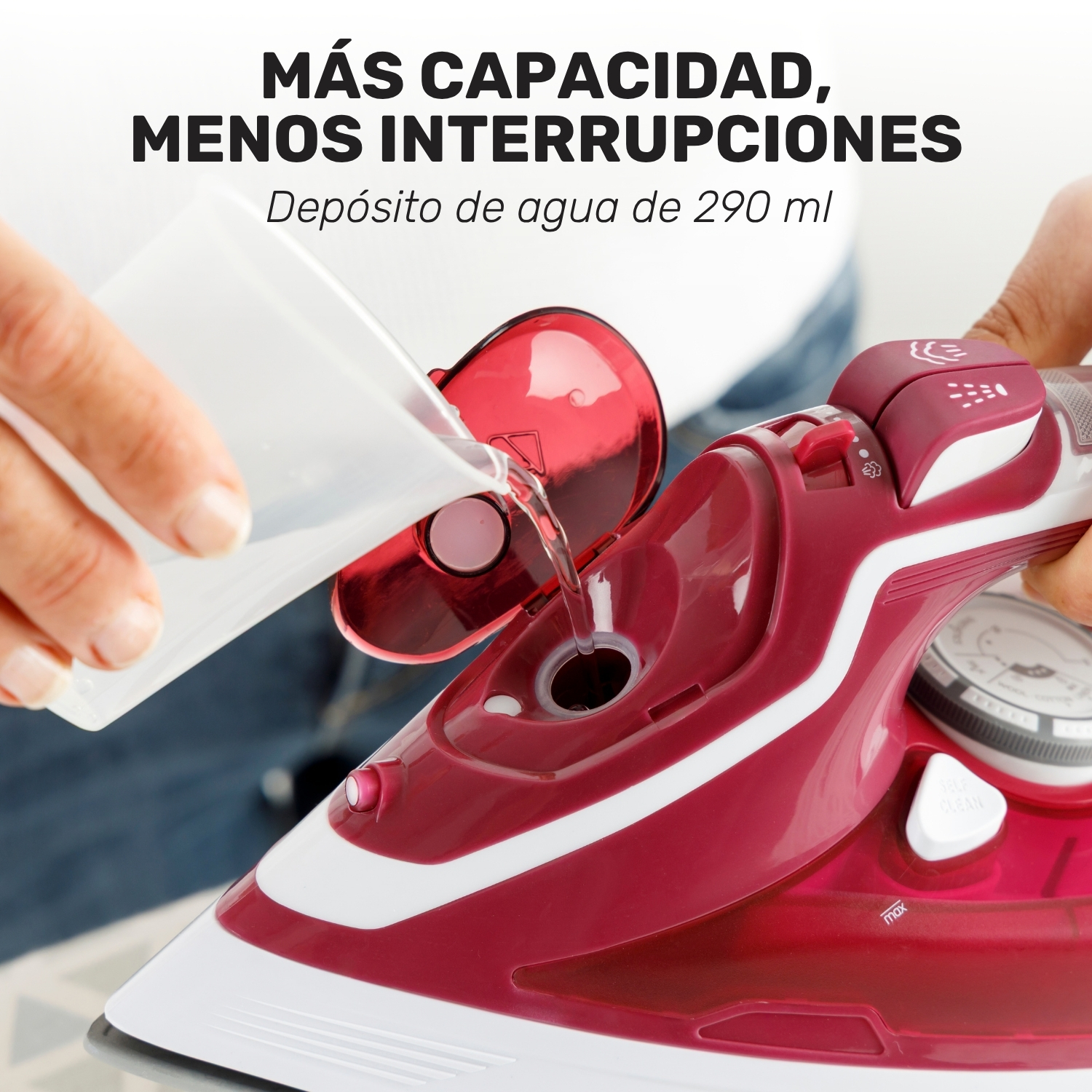 Se vierte agua desde un vaso medidor en el depósito abierto de una plancha roja y blanca.