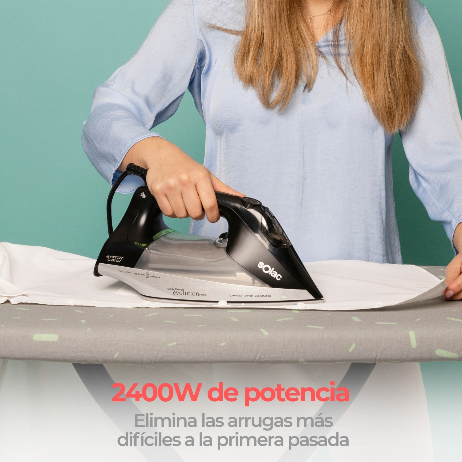 Una mujer plancha una camisa blanca con una plancha Solac negra sobre una tabla de planchar gris.