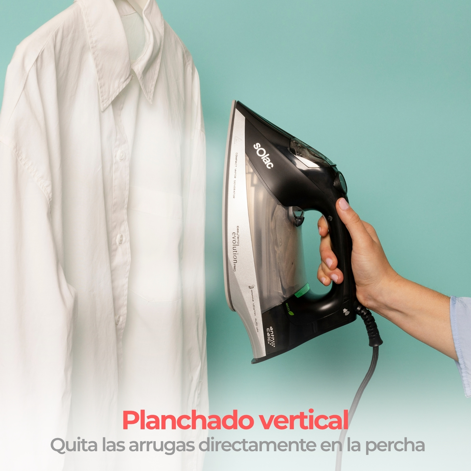 Una mano sostiene una plancha negra Solac, aplicando vapor a una camisa blanca en una percha.