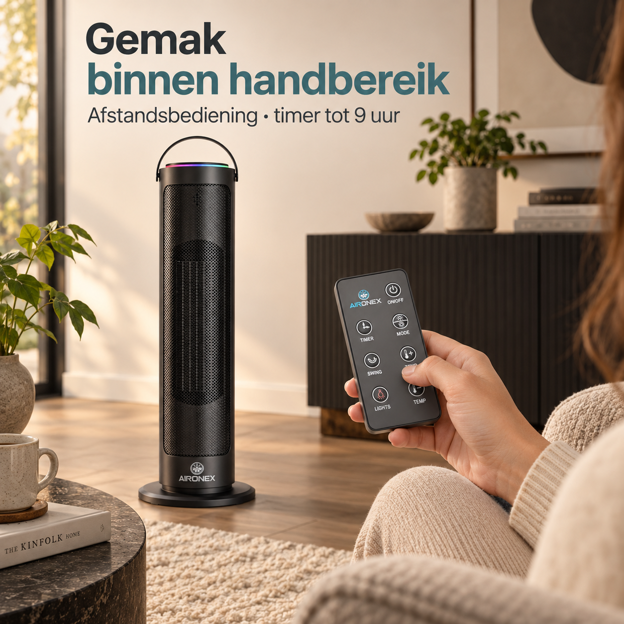 Eine Person hält eine schwarze Fernbedienung und richtet sie in einem hellen Wohnzimmer auf einen schwarzen Säulenheizer.