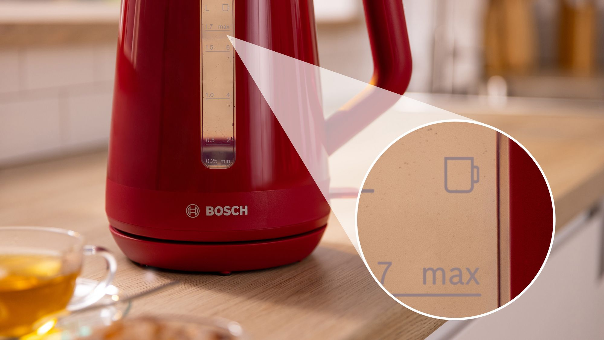 Un hervidor eléctrico rojo de Bosch sobre una encimera de madera con un círculo de aumento en el nivel máximo.