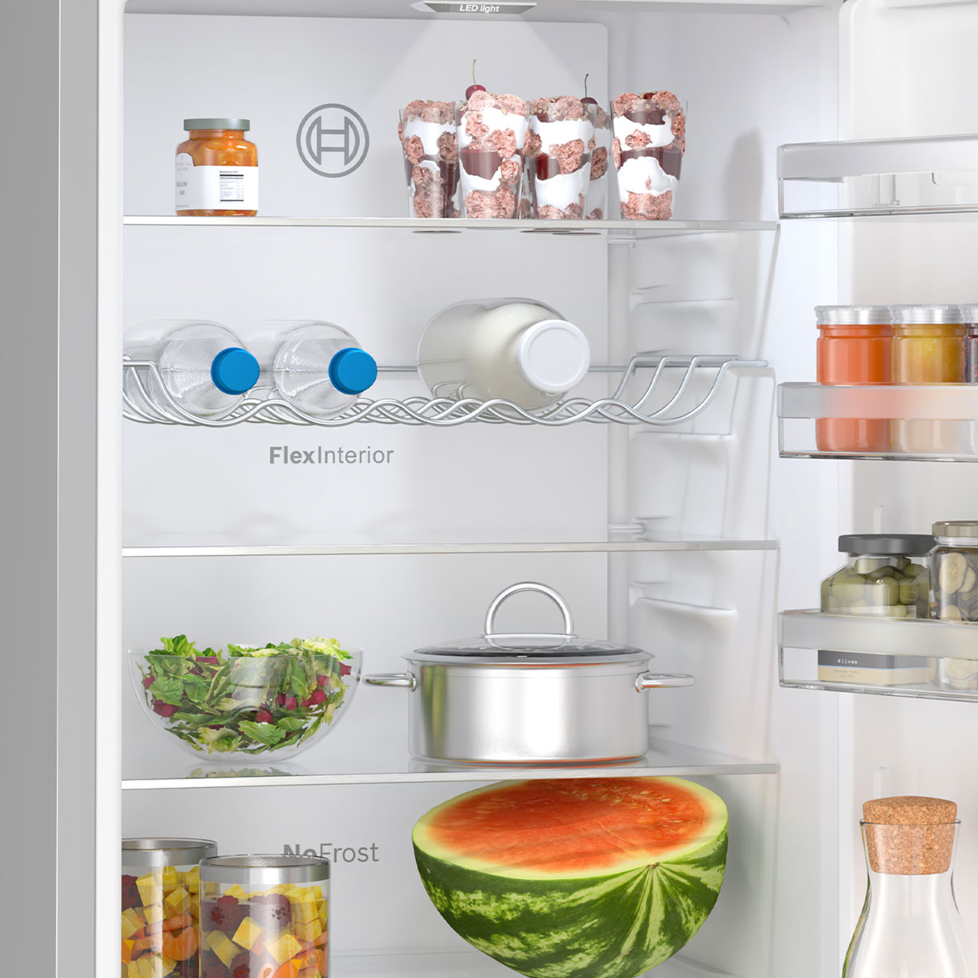 Geöffneter, weißer Bosch Kühlschrank mit Lebensmitteln, Getränken, einem Topf und einer halben Wassermelone.