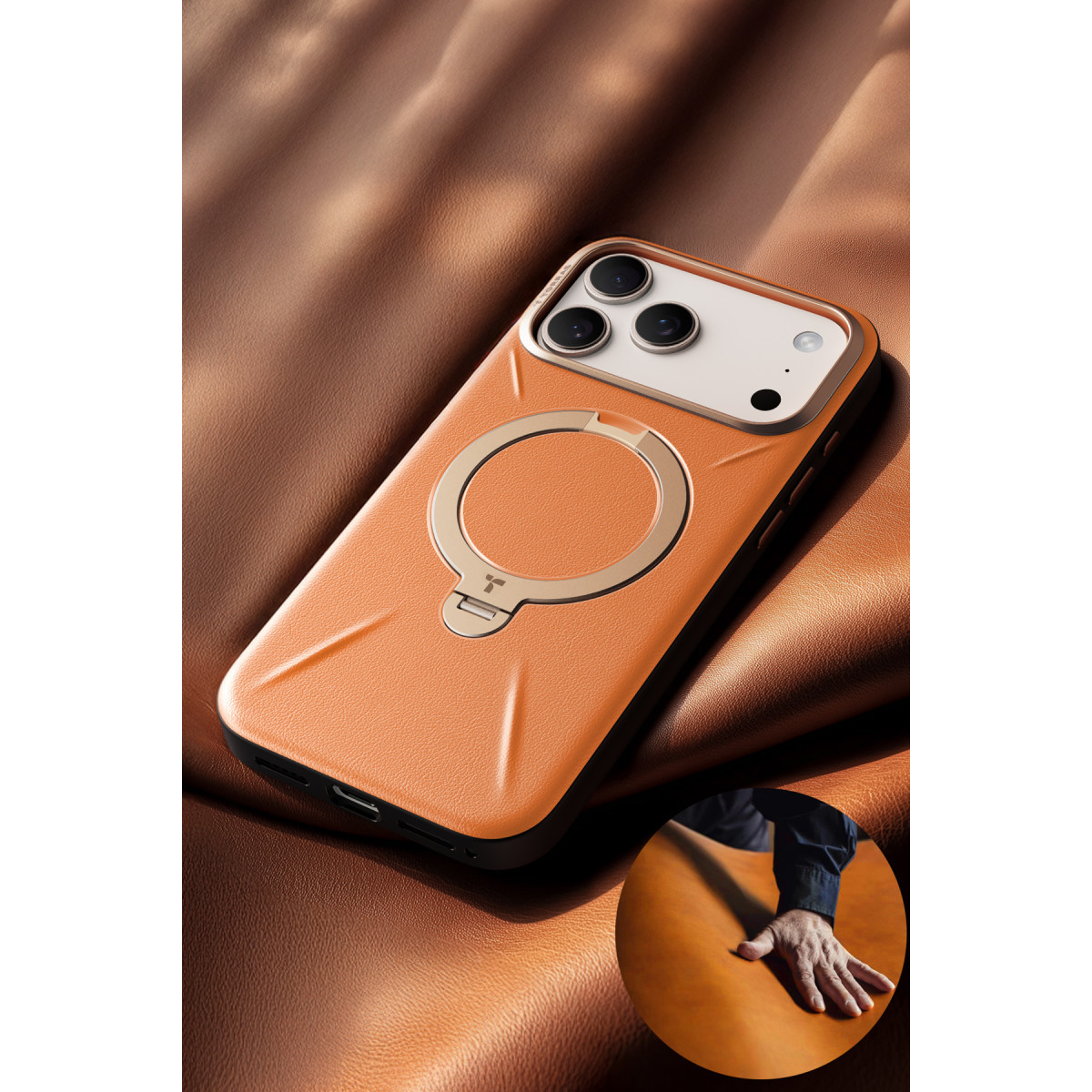 Kahverengi deri arka planda metal halkalı turuncu telefon kılıfı ve el gösteren yuvarlak bir iç kısım.