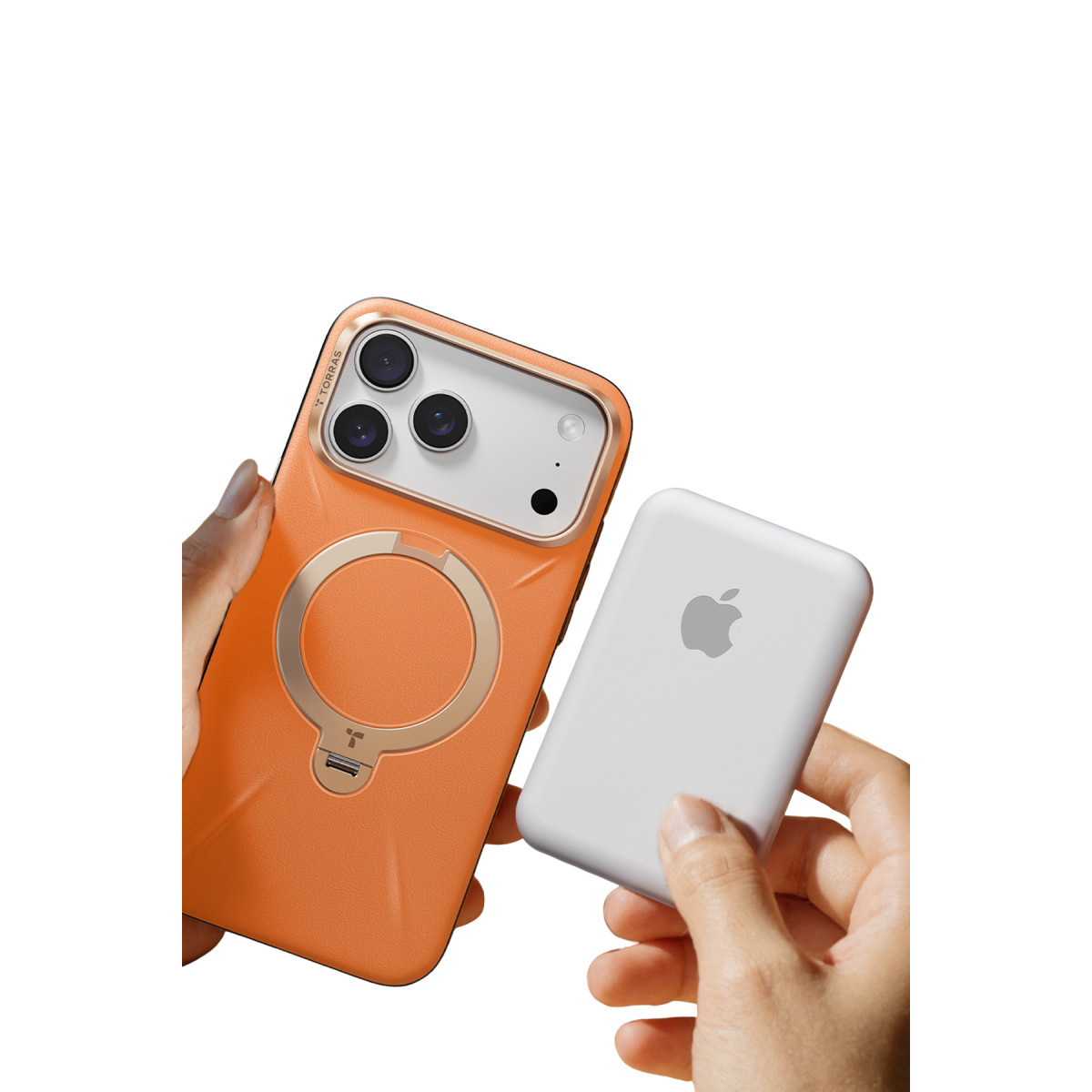 Bir el halka standlı turuncu bir akıllı telefonu, diğeri ise beyaz bir Apple MagSafe pil takımını tutuyor.