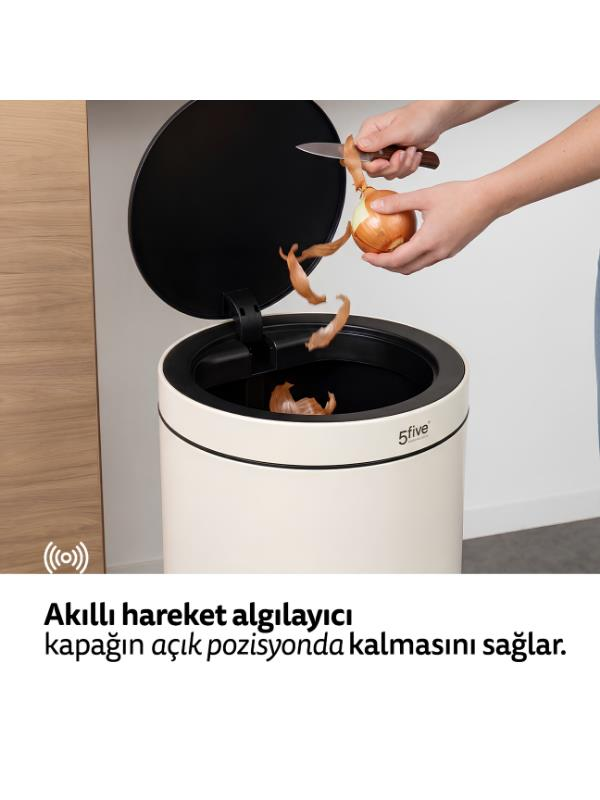Bir kişi açık bej renkli çöp kovasına soğan kabuklarını atıyor.
