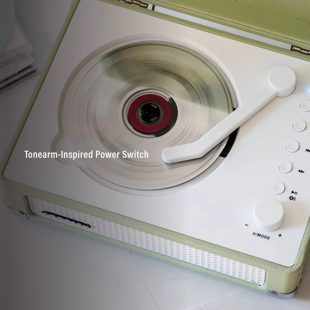 Hellgrüner retro CD-Player mit weißer Bedienkonsole, rotem CD-Kern und tonarmähnlichem Schalter.