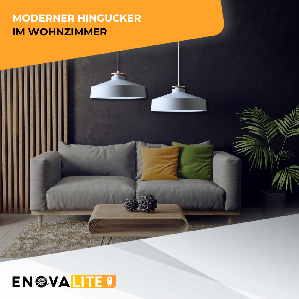 Moderne graue Couch mit Holztisch und zwei Hängelampen vor dunkler Wand.