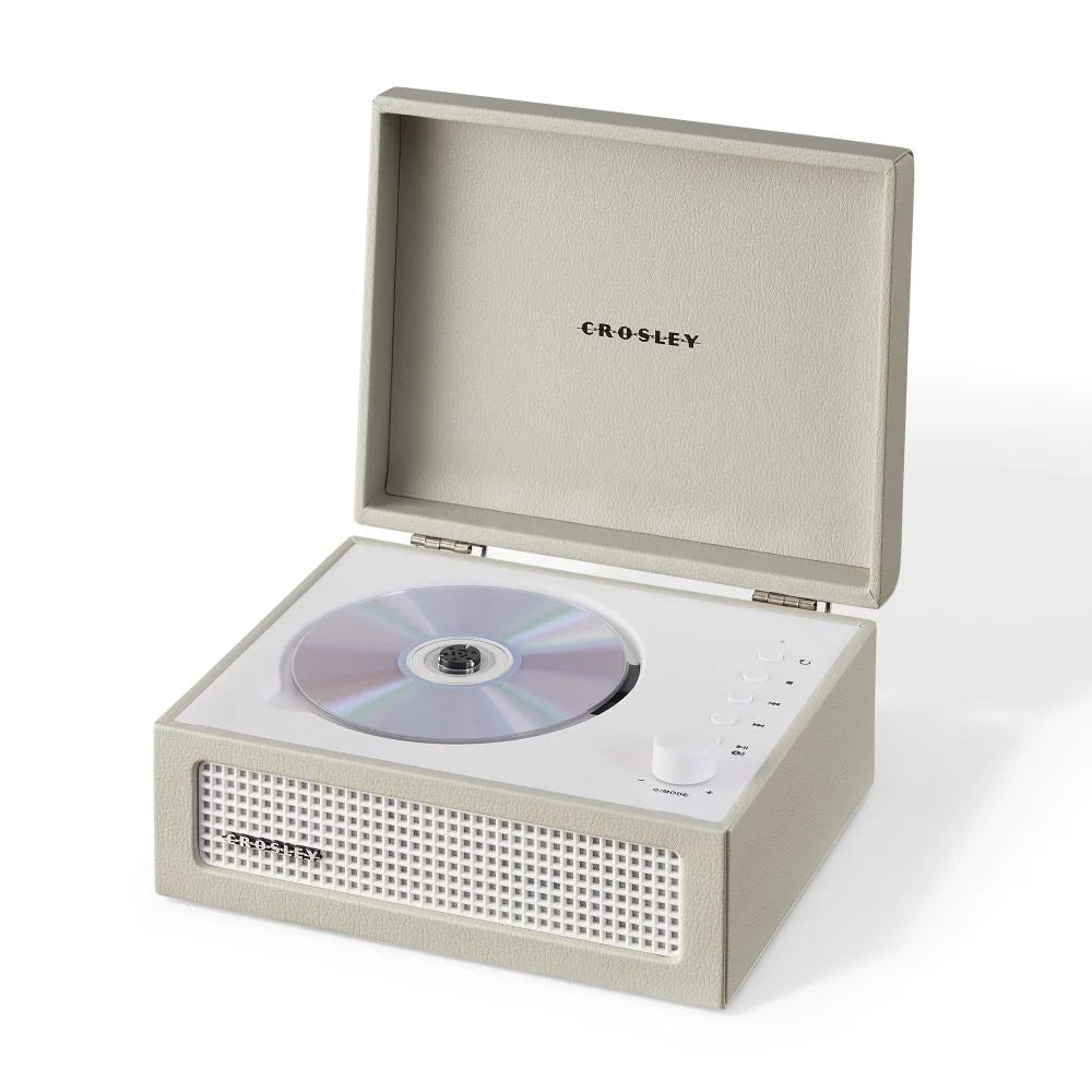 Ein cremefarbener Crosley CD-Player in Kofferform mit eingelegter CD und weißem Lautsprechergitter auf weißem Grund.