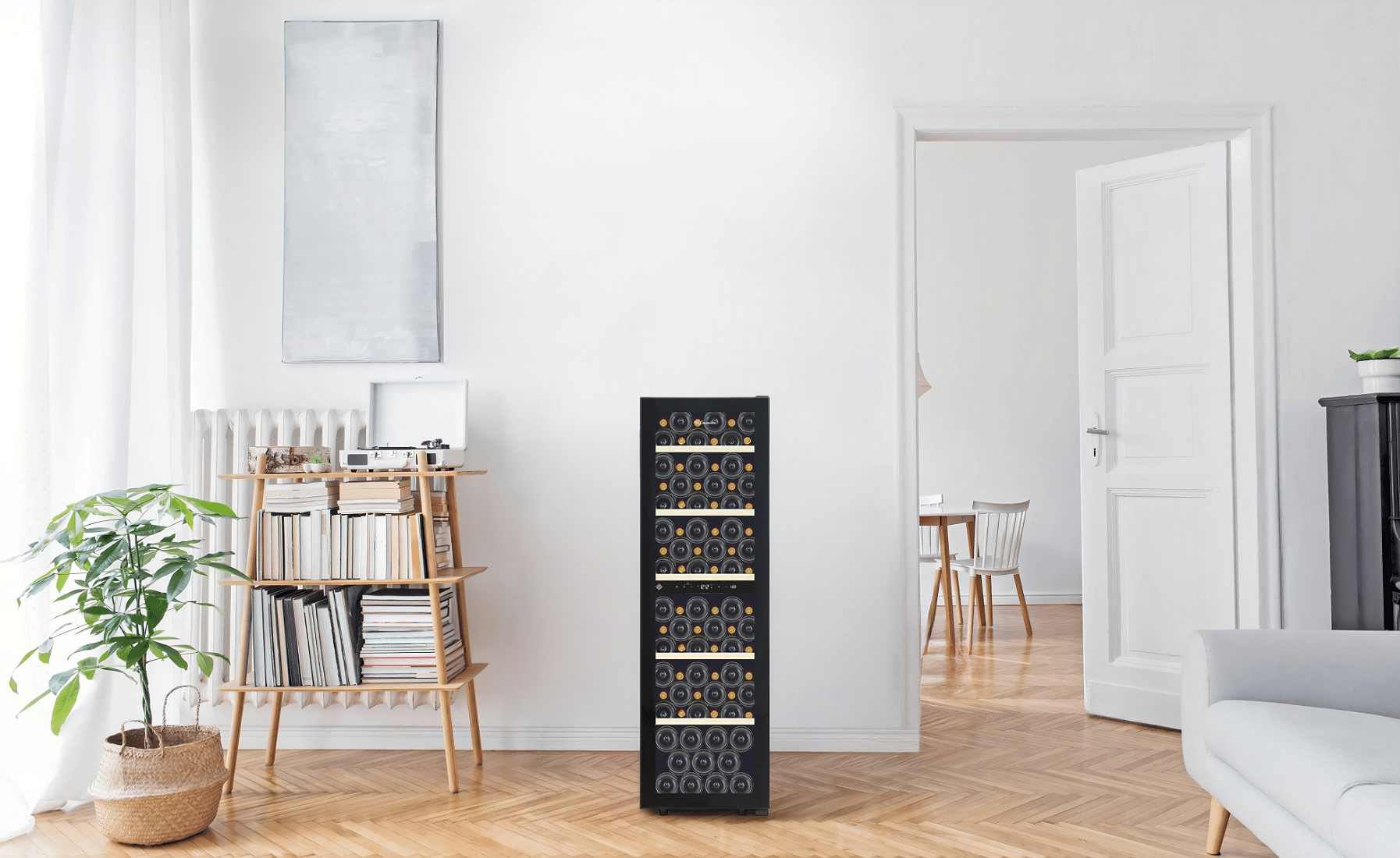 Un enfriador de vino negro se encuentra en una habitación luminosa junto a una estantería.