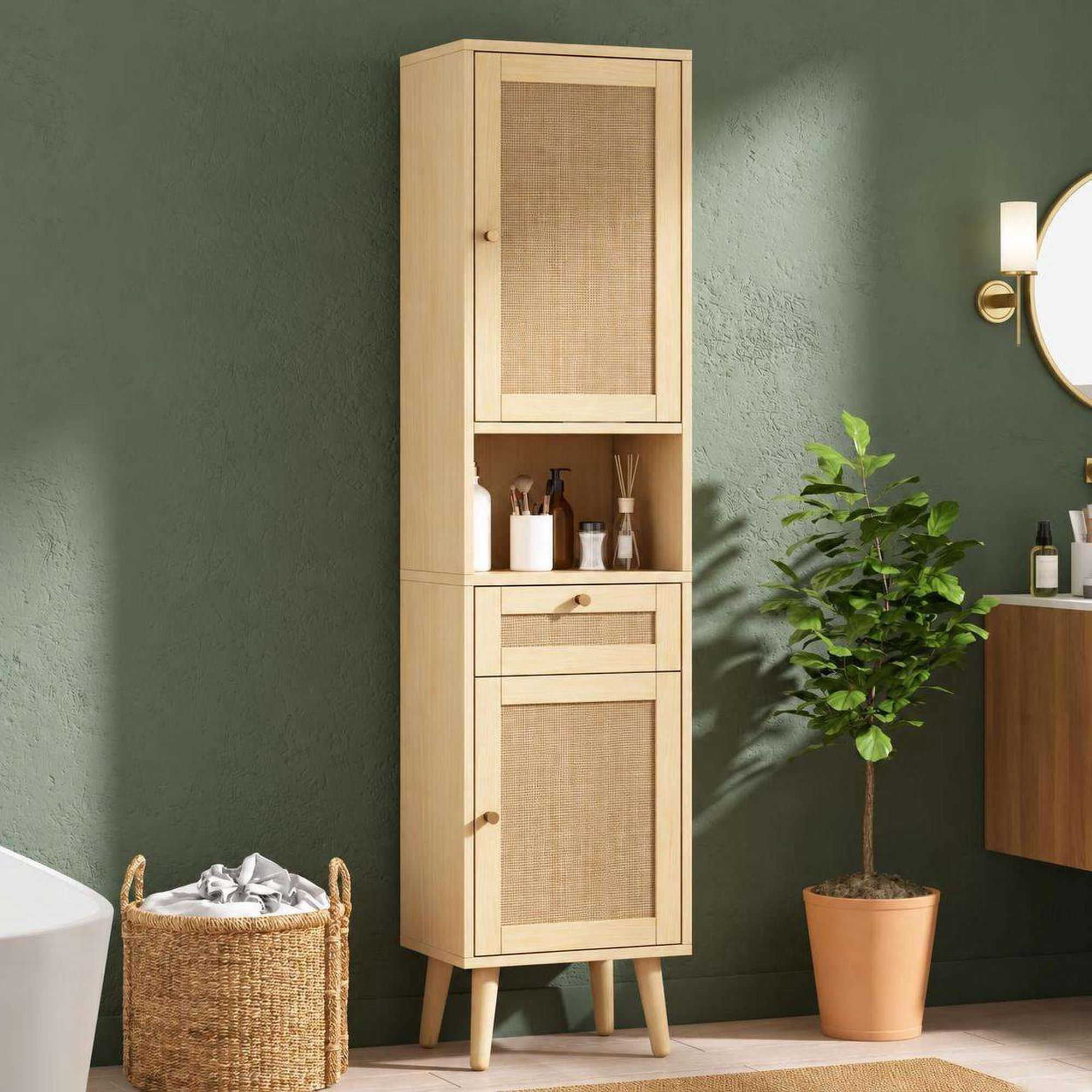 Ein großer, heller Holzschrank mit Rattantüren steht an einer grünen Wand in einem Badezimmer.