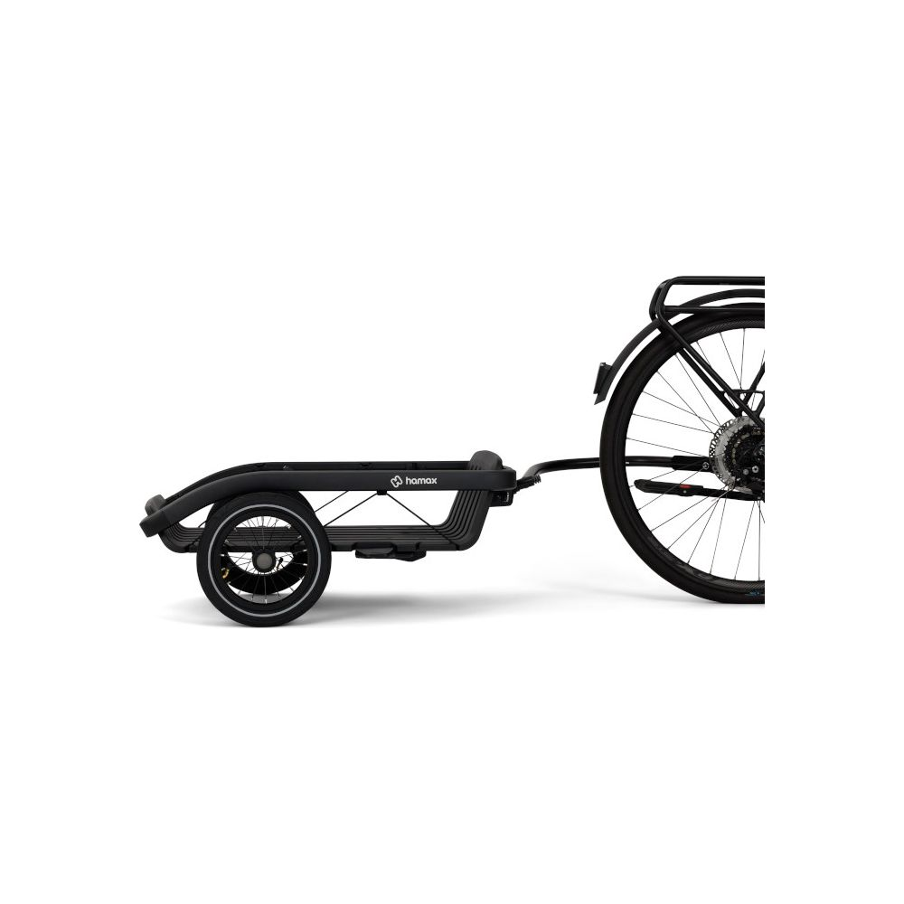 Ein schwarzer Fahrrad-Lastenanhänger ist am Hinterrad eines Fahrrads befestigt, seitlich vor weißem Hintergrund.