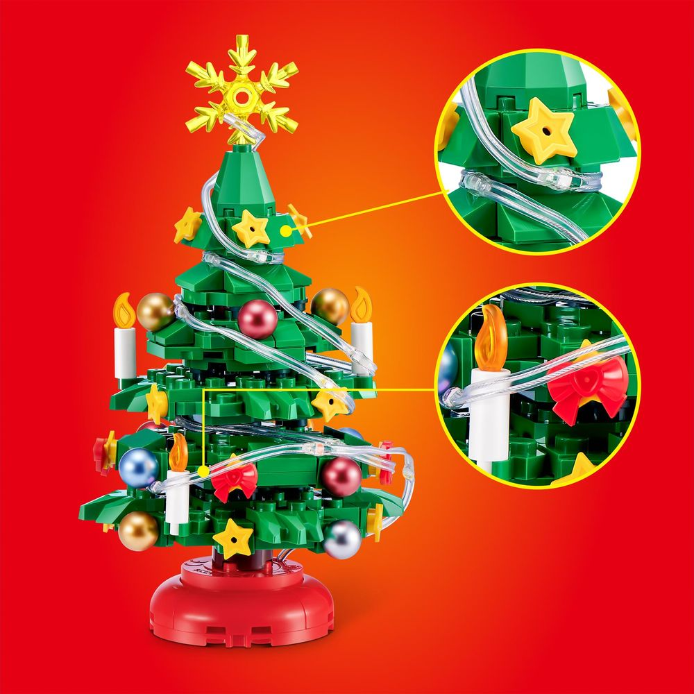 Ein Weihnachtsbaum aus Bausteinen mit Lichtern, Kugeln und einem goldenen Stern, vor rotem Hintergrund.