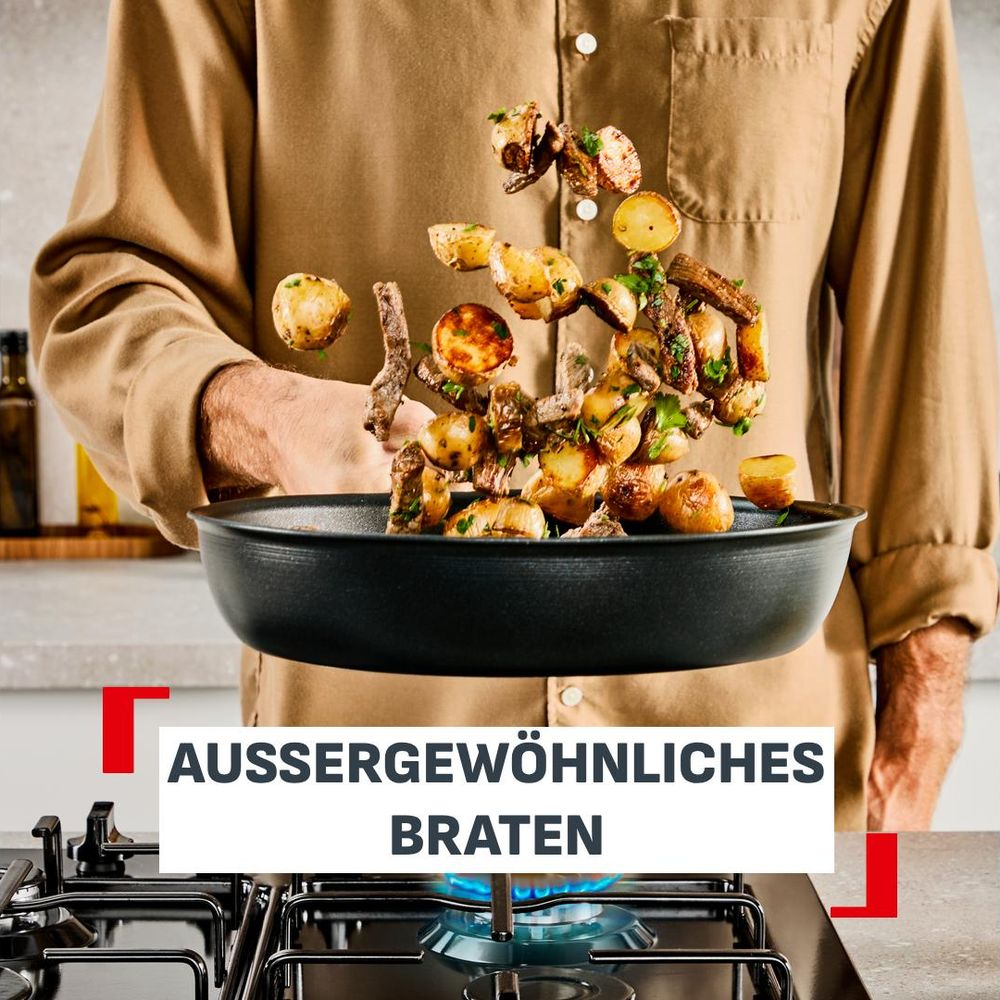 Ein Koch wirft Kartoffeln und Fleisch aus einer schwarzen Pfanne über einem Gasherd, mit dem Text AUSSERGEWÖHNLICHES BRATEN.