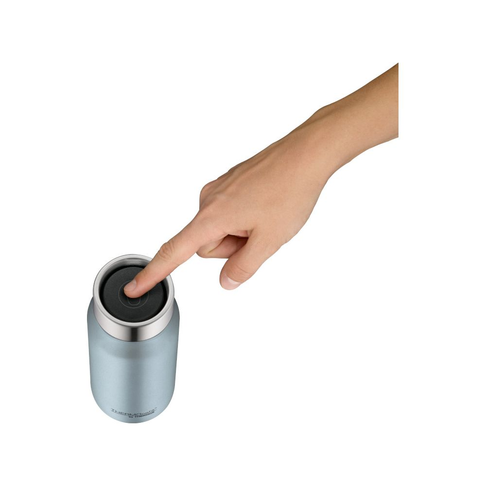 Eine Hand drückt auf den schwarzen Deckel einer blauen Thermosflasche.