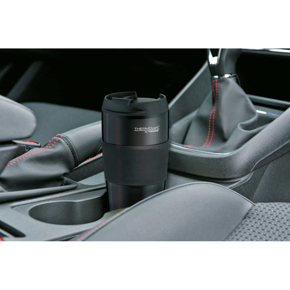 Ein schwarzer Thermobecher steht in der Mittelkonsole eines Autos.