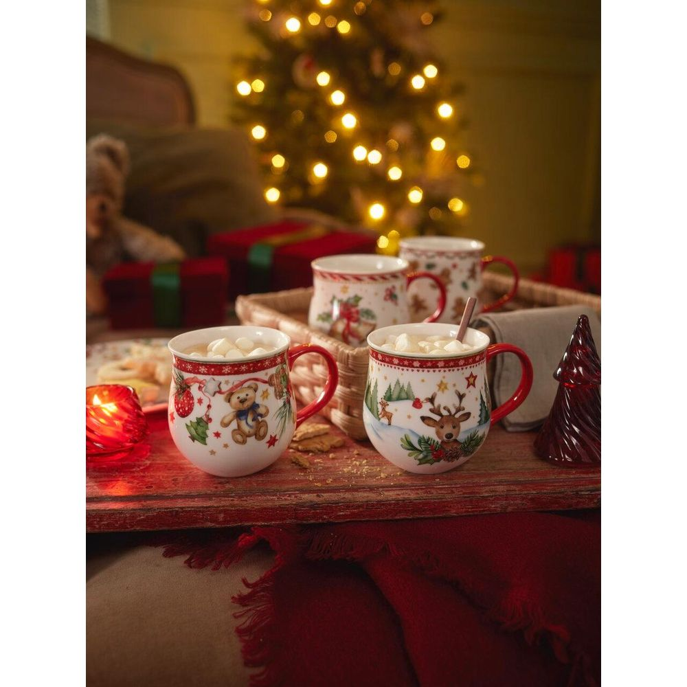Weihnachtliche Tassen mit Marshmallows auf einem Tablett, mit Lichtern und Geschenken im Hintergrund.