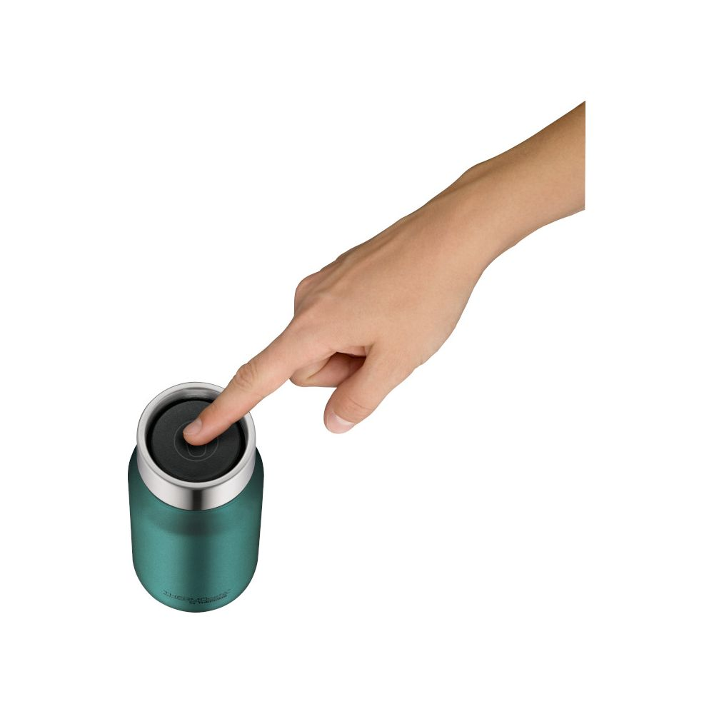 Eine Hand drückt auf den schwarzen Deckel einer grünen Thermoskanne vor weißem Hintergrund.