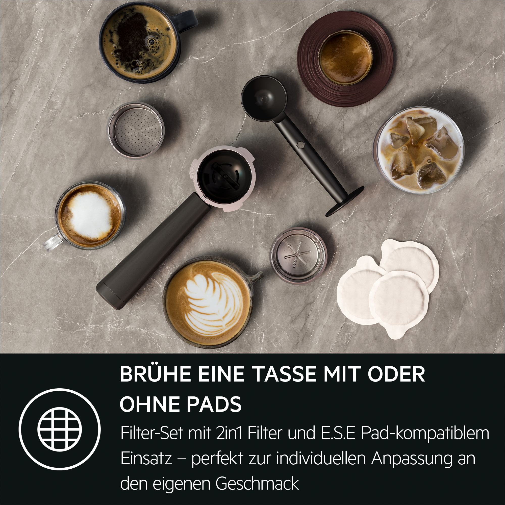 Kaffeezubehör wie Kaffeepads, Siebträger, Kaffeetassen mit Latte Art und ein Tamper auf grauem Untergrund.