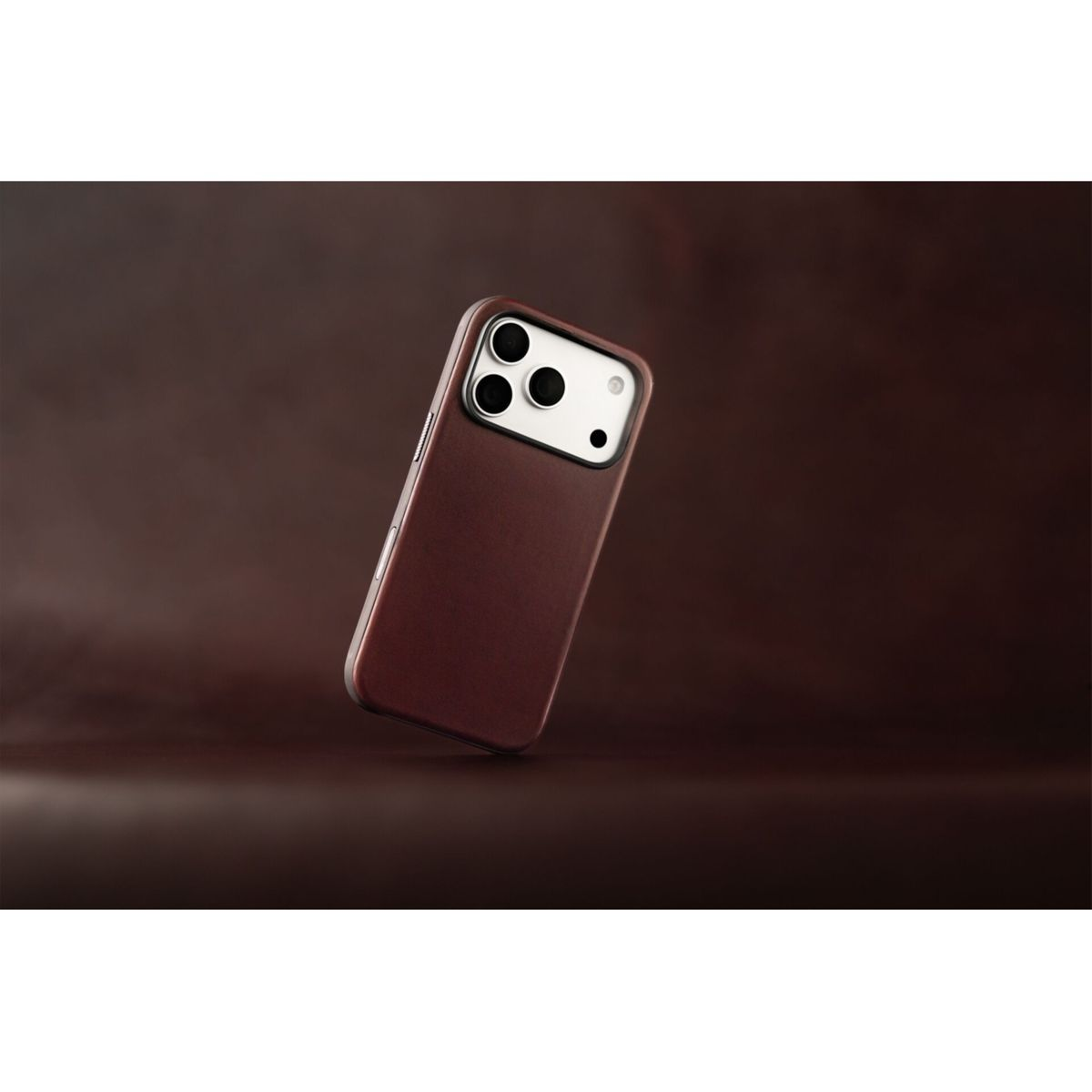 Ein Smartphone mit brauner Lederhülle und einer rechteckigen Kameraaussparung schwebt vor einem braunen Hintergrund.