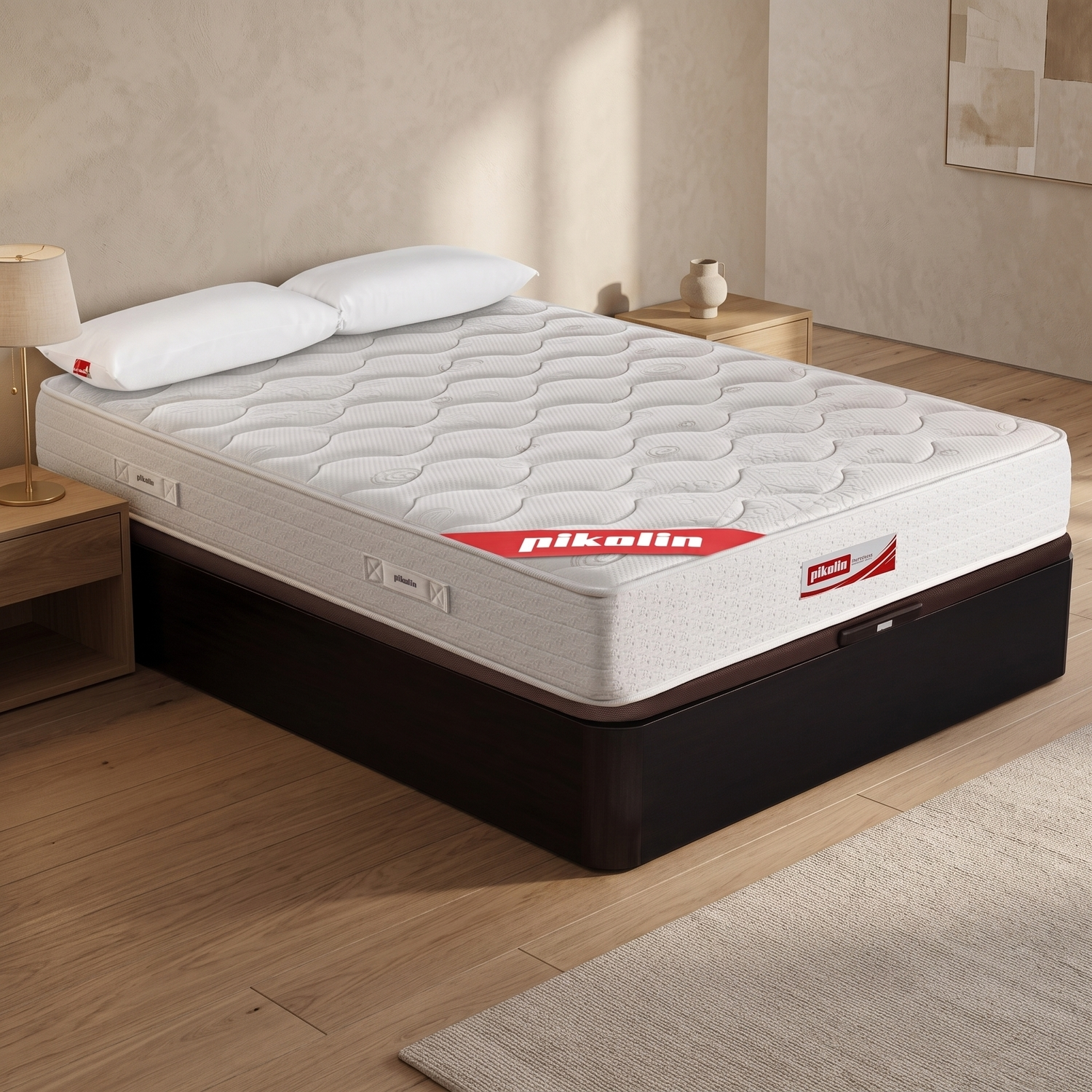 Un colchón blanco Pikolin con dos almohadas sobre una base oscura en un dormitorio minimalista con suelo de madera.
