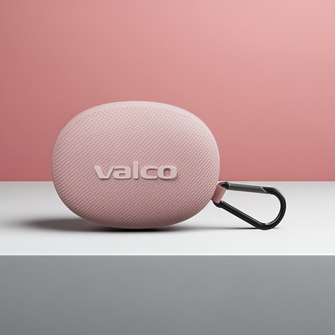 Rosa, ovale Valco-Hülle mit einem schwarzen Karabinerhaken auf einer weißen Oberfläche vor rosa Hintergrund.