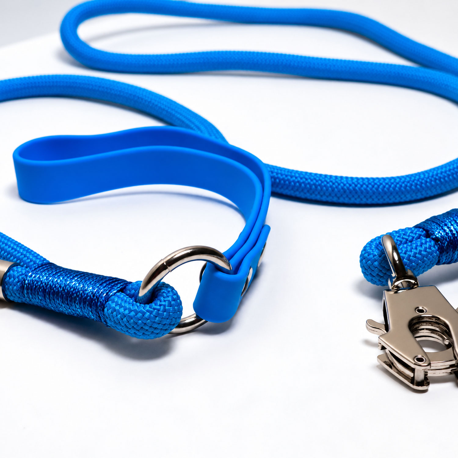 Una correa de perro de cuerda azul brillante y collar a juego con herrajes de metal plateado.