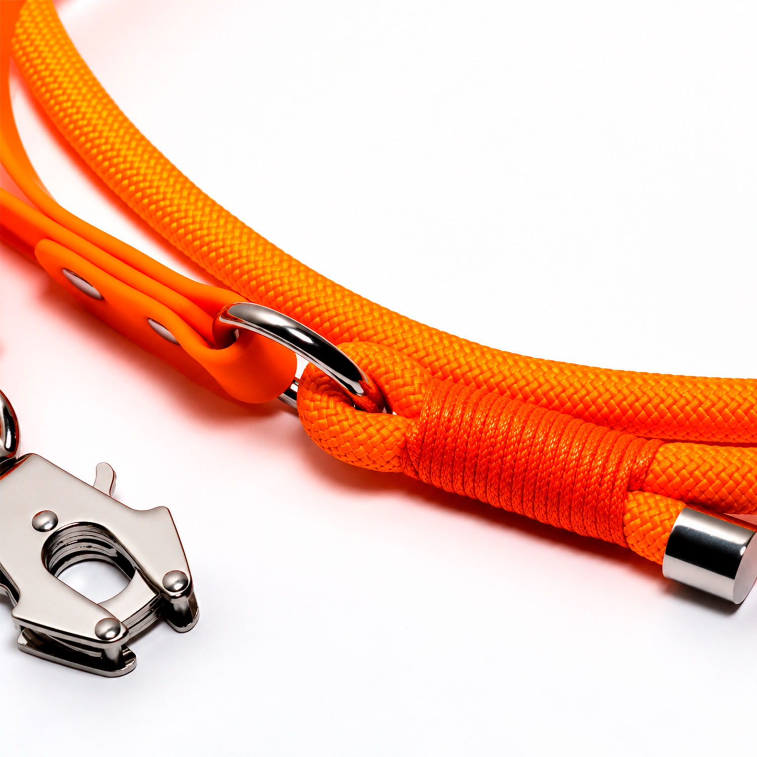 Una correa de perro de cuerda de color naranja brillante con herrajes de metal plateado sobre un fondo blanco.
