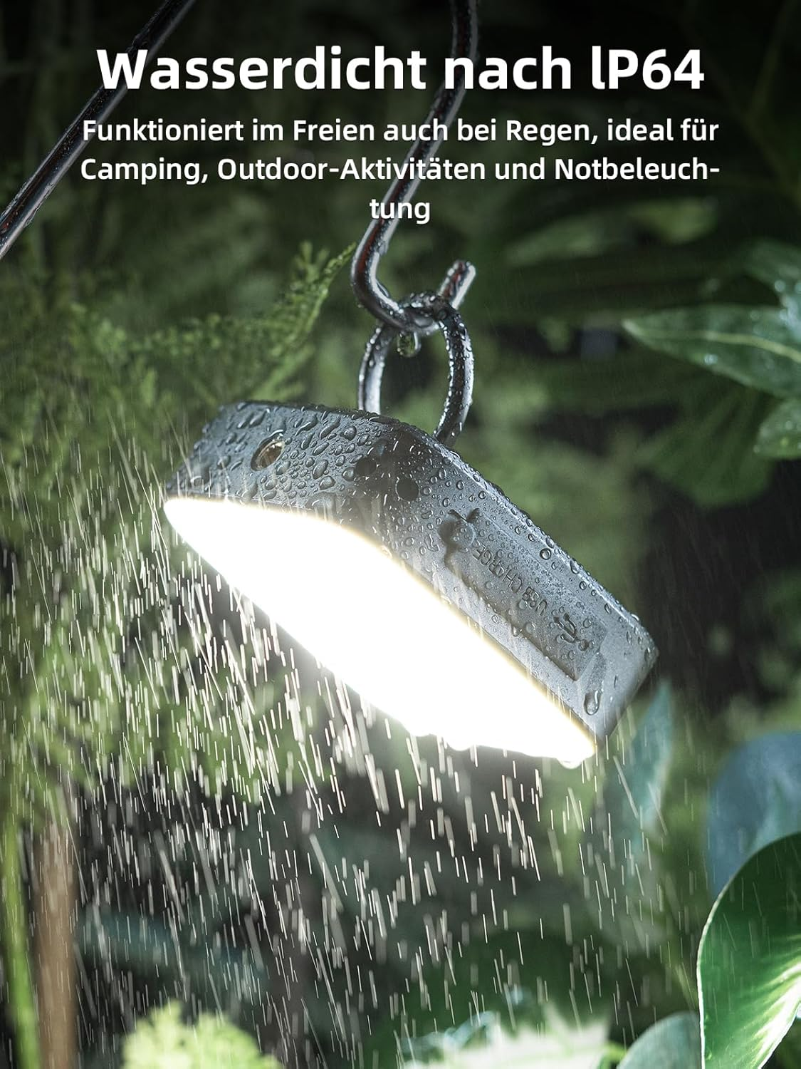 Wasserdichte Campinglampe hängt im Regen an einem Haken. Licht leuchtet hell im grünen Garten.