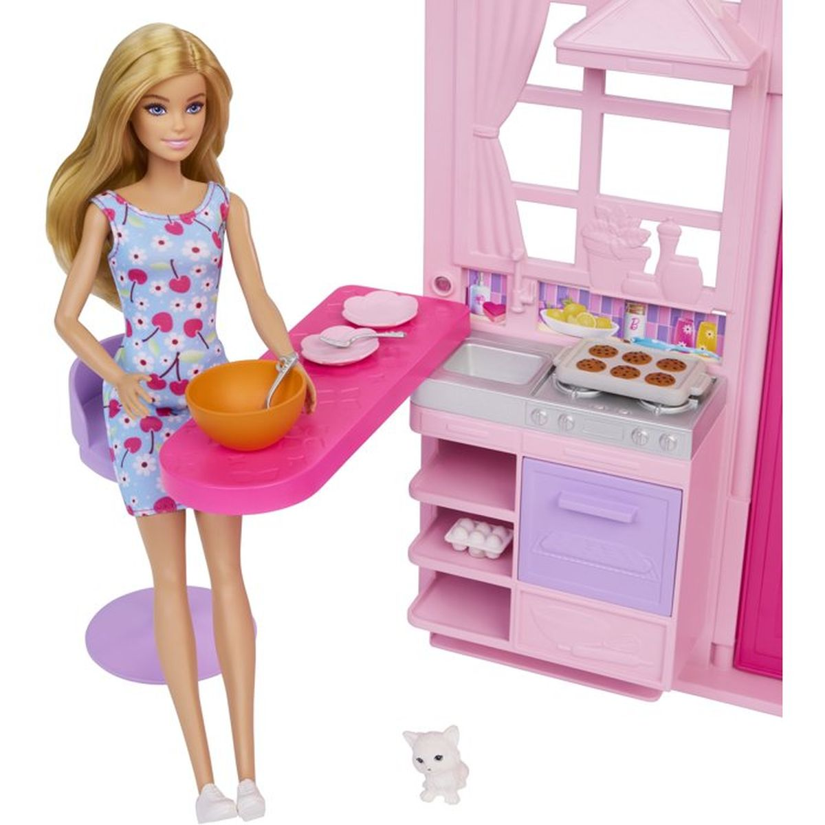 Eine blonde Barbie-Puppe steht neben einer rosa Spielzeugküche mit einer Schüssel, eine kleine weiße Katze am Boden.