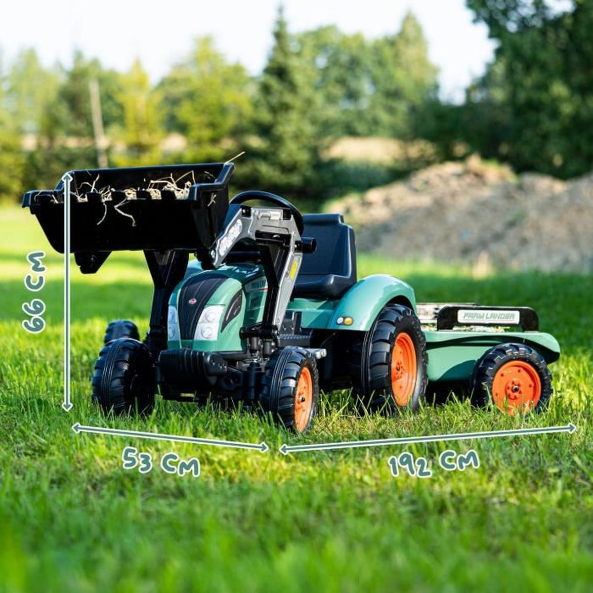 Grüner Kindertraktor mit Frontlader, Anhänger und Maßangaben auf Rasen.