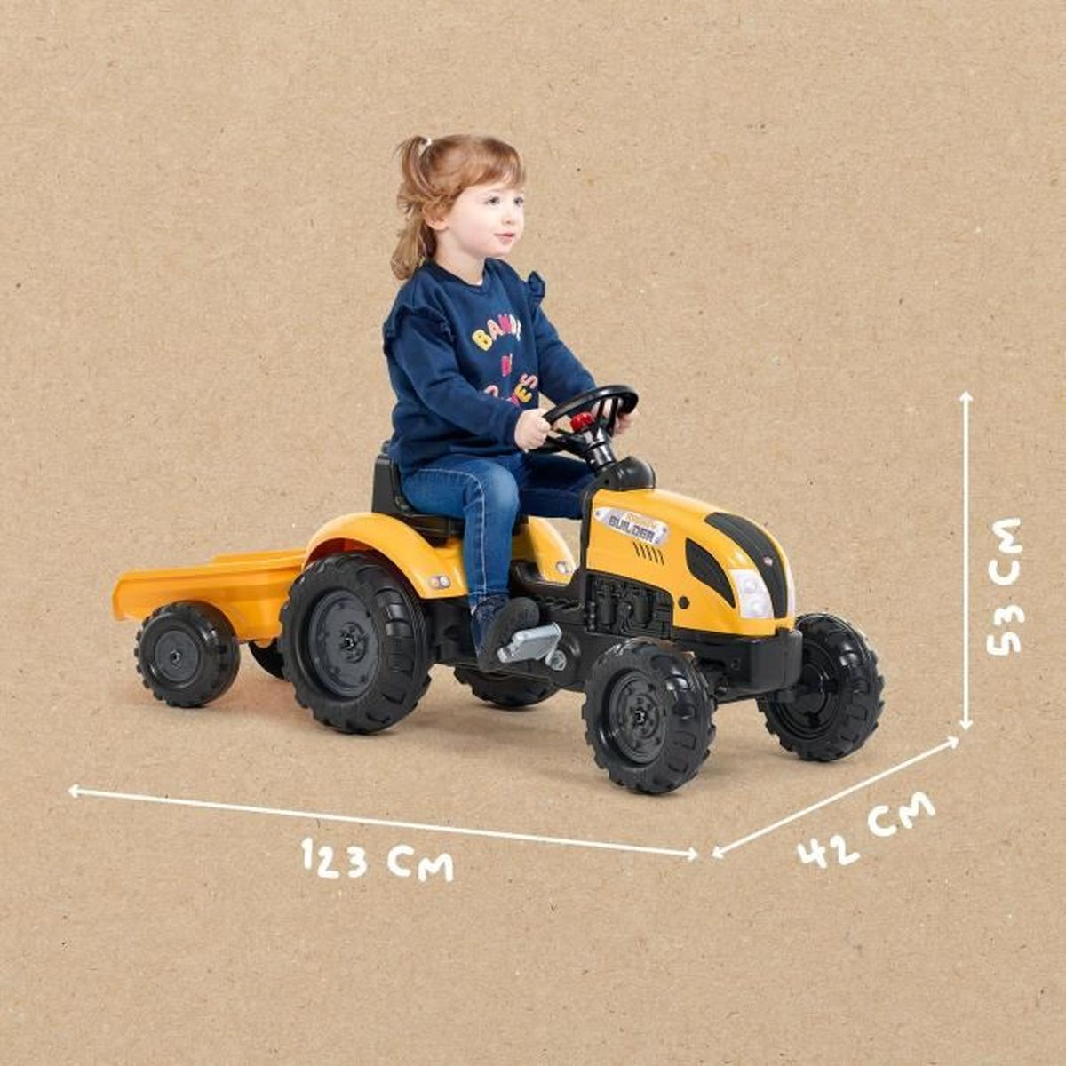Ein Kind sitzt auf einem gelben Spielzeugtraktor mit Anhänger, Maße: 123x42x53 cm.