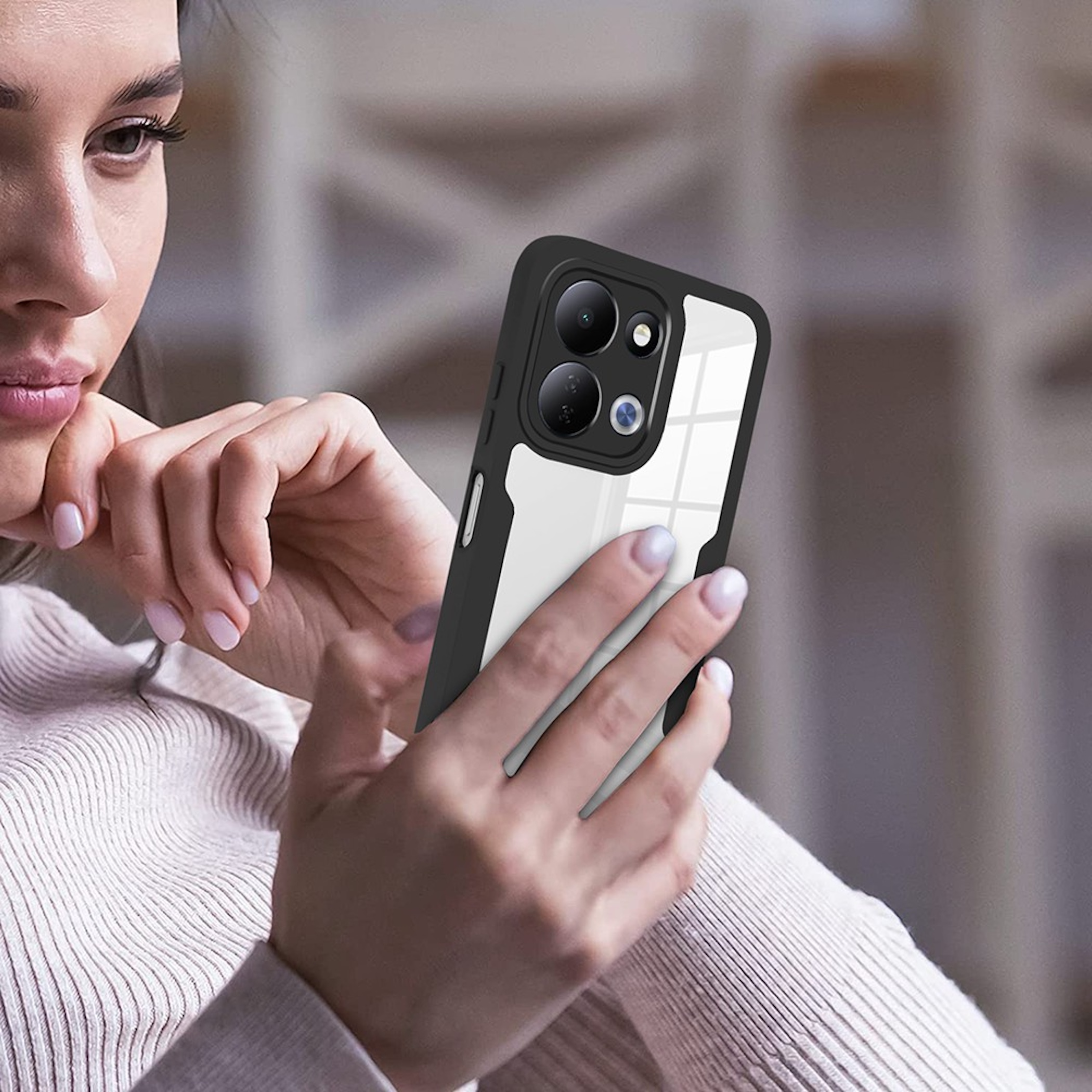 Eine Frau hält ein Smartphone mit schwarzer Hülle und klarer Rückseite in den Händen.