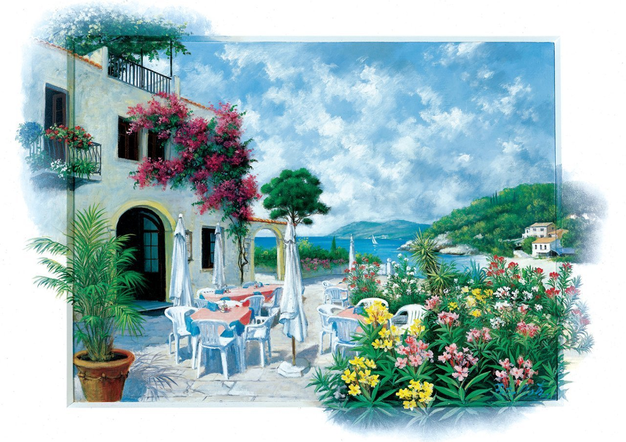 Açık hava masaları, renkli çiçekler ve deniz manzarası olan kıyı restoranı.