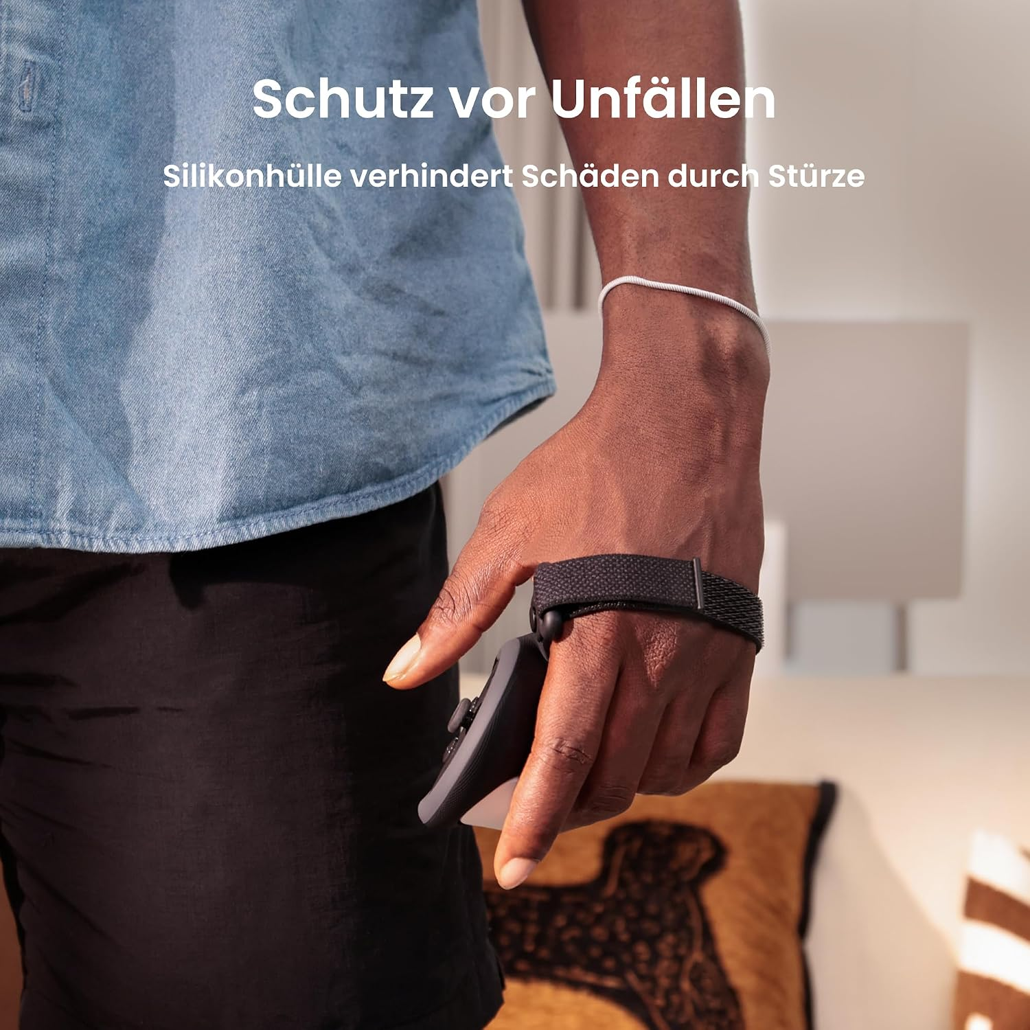Person hält eine VR-Controller mit Schutzhülle und Handschlaufe in einem hellen Raum.