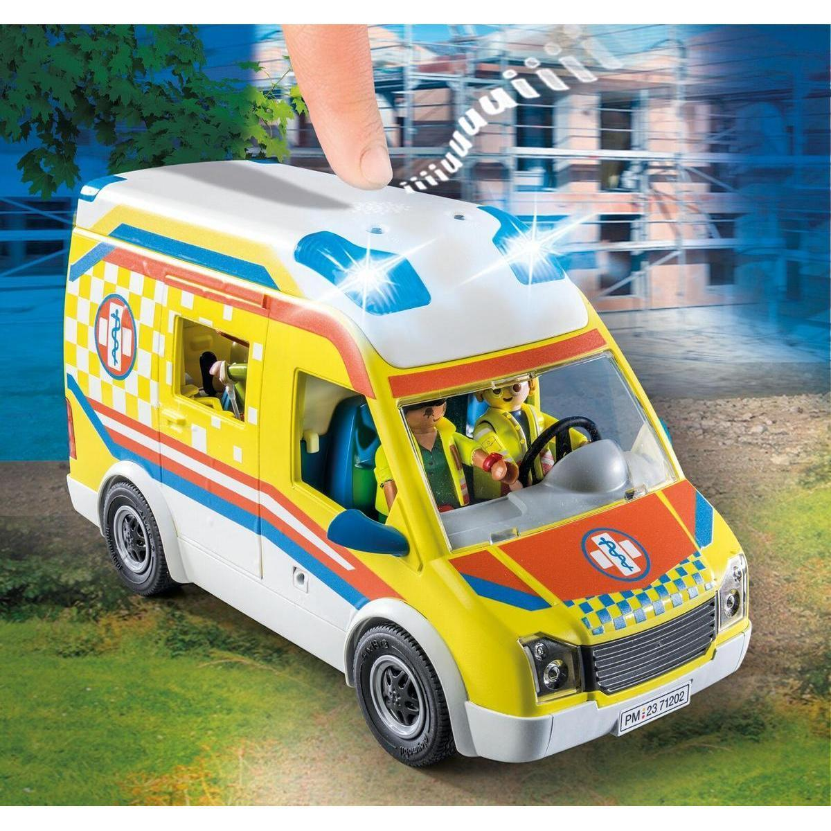 Una ambulancia Playmobil amarilla y blanca con luces intermitentes y figuras en una carretera.