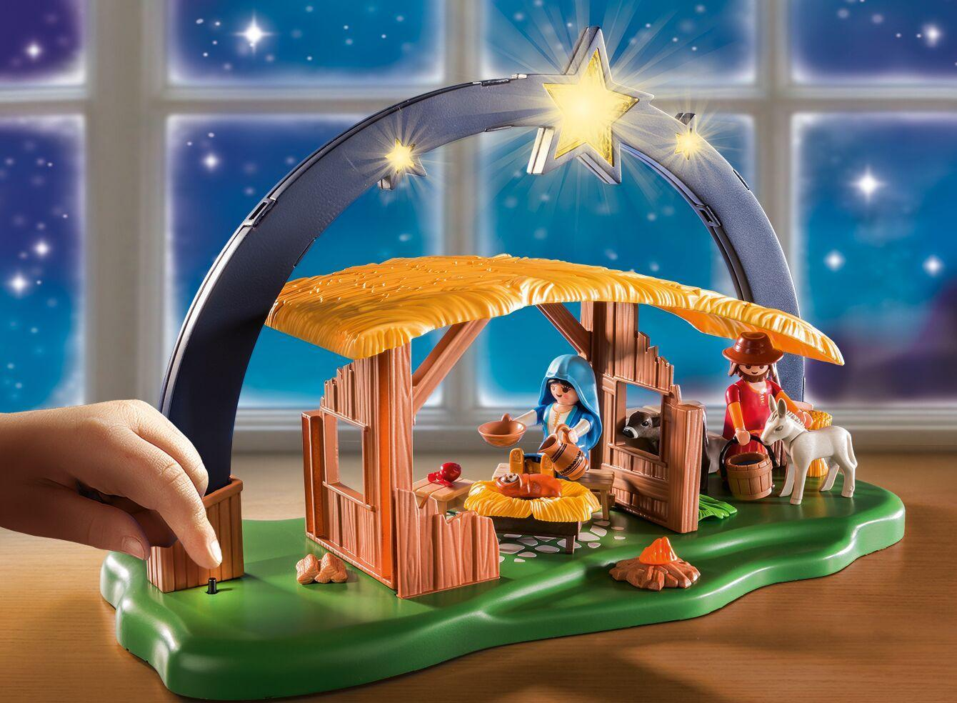 Belén de Playmobil con establo, María, José, el niño Jesús en un pesebre, animales y arco luminoso.