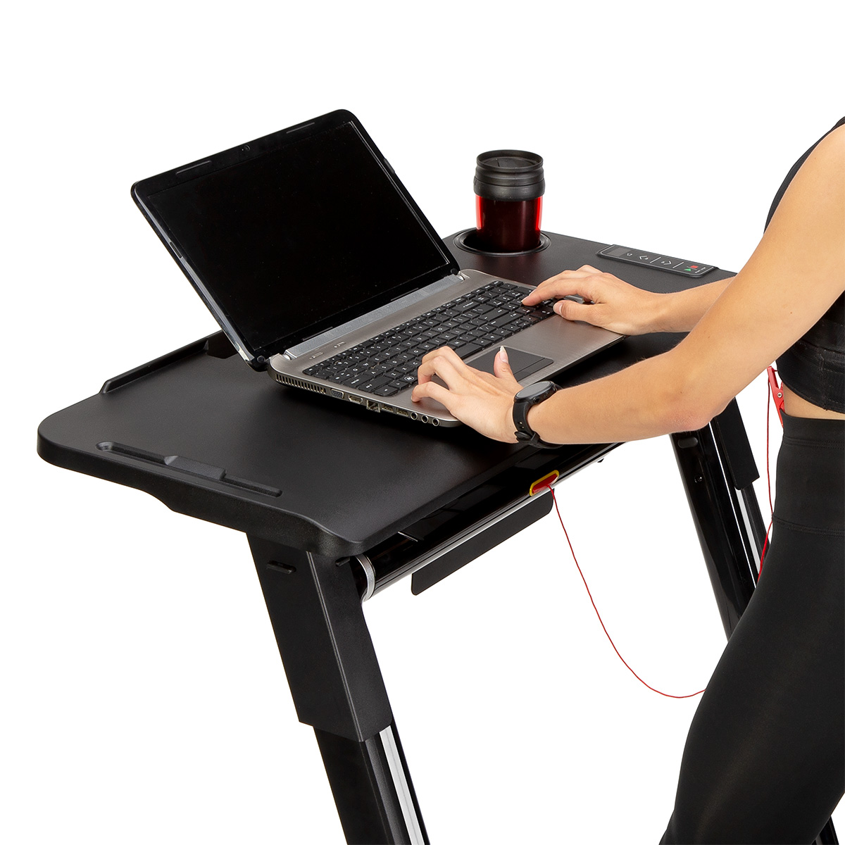 Kobieta w stroju sportowym korzysta z laptopa na biurku bieżni na białym tle.