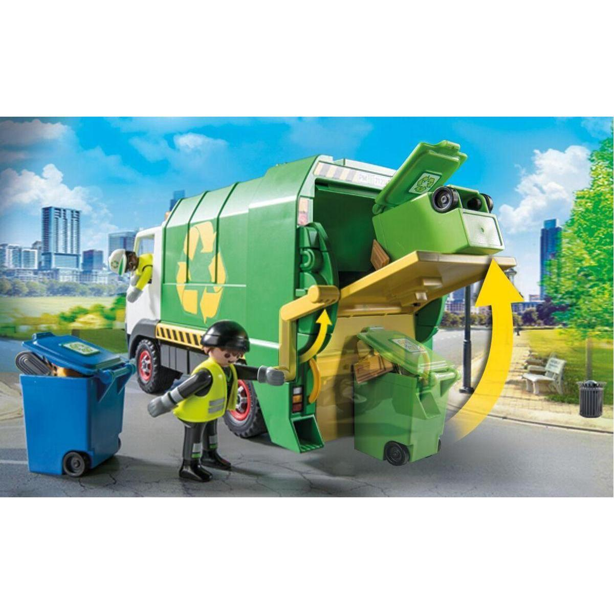 Un camión de basura de juguete descarga contenedores verdes mientras un trabajador está cerca.
