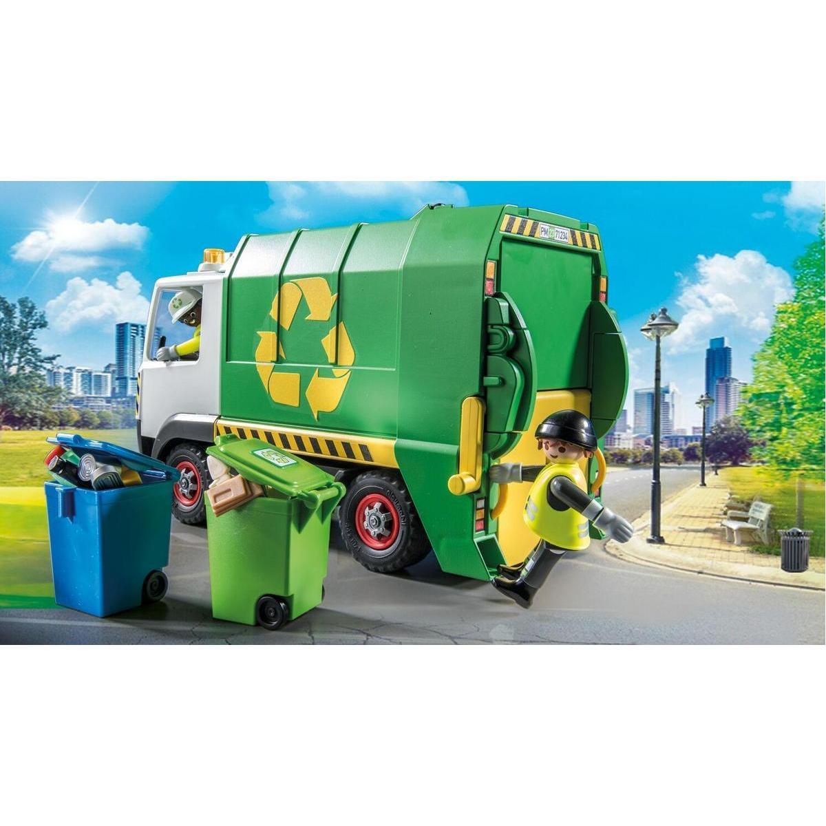 Un camión de basura verde con trabajadores y contenedores azul y verde en una calle frente a una ciudad.